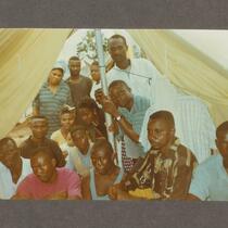 Group under a tent in an Ogoni refugee camp